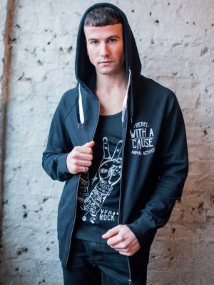 A male model standing against a white wall wearing a vegan activist hoodie phtograpghed from the front