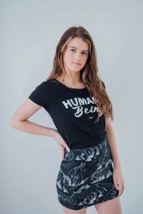 Vegan Model wearing all over animal print mini skirt matched with a humane being tshirt