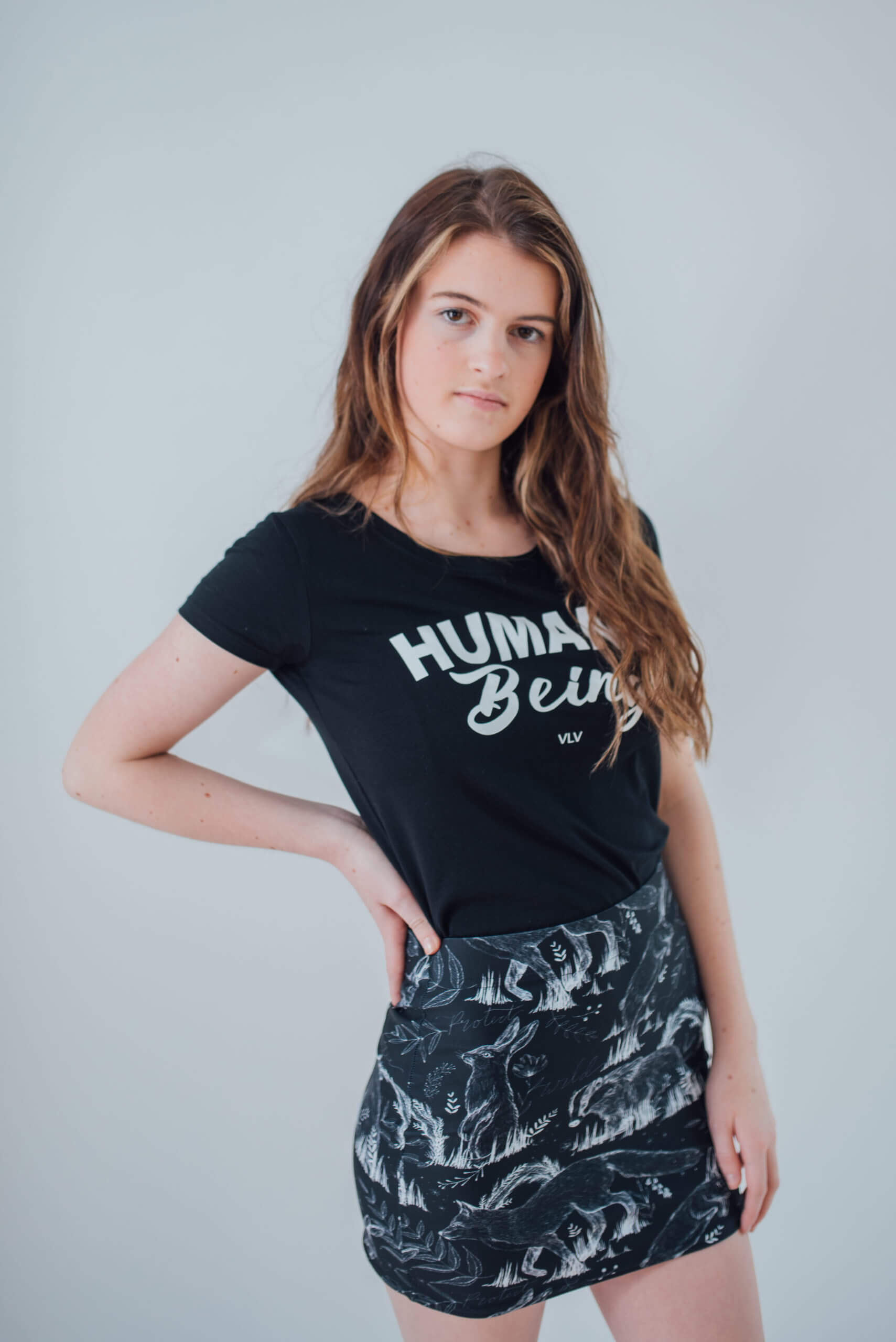 Vegan Model wearing all over animal print mini skirt matched with a humane being tshirt
