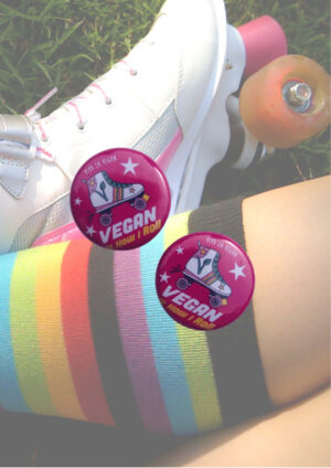 A picture of a pair of vinatge roller skates with an overlay of the product being sold which is a small (25mm) sized badge with a rooler skate and the words "Vegan Skater - Thats how I roll" on it. Designed by Viva La Vegan.