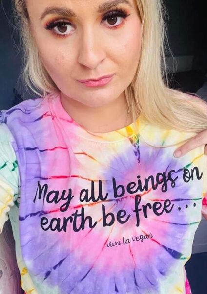 Blonde girl wearing vibrant tie dye tshirt with May all beings be free chest print by eco ethical brand Viva La Vegan