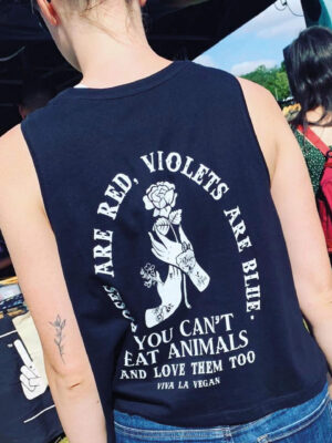 Back of festival girl wearing a black vest with the graphic, Roses are red violets are blue you can't eat animals and love them too. Be Viva La Vegan