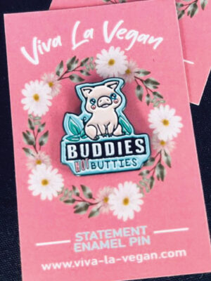 Pink pig pin on a turquoise background with the wording Buddies NOT Butties. By Eco ethical brand Viva La Vegan