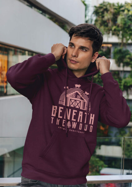 young man wearing a burgundy Beneath the wood logo hoodie