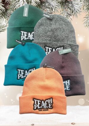 Flatlay photo of 5 cuffed beanies with a black and white embroidery 'Teach Peace - Live Vegan.