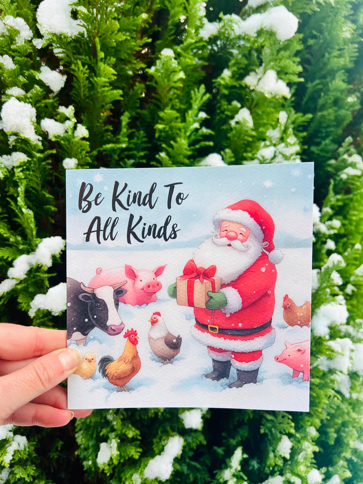 A sweet Christmas card design with Santa in the snow giving presents to smiling farm animals. with the text be Kind to all kind