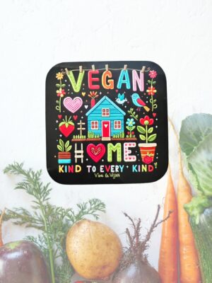 Vegan statement coaster with the wording Vegan Home a picture of a brightly coloured house in the style of embroidery. Black background with a colourful design